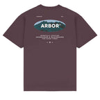 A dark plum purple short-sleeve t-shirt with a graphic on the back. The graphic features an oval logo with a mountain background and the word 'ARBOR' in white, along with smaller white text reading 'VENICE CA' and 'WINDFULLY DRAFTER ENBOARDERS & SKATEBOARDS FOR GOOD 7:42$'.