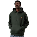 A man wearing a dark forest green Carhartt hoodie with a small embroidered Carhartt logo on the left chest, set against a plain white background.