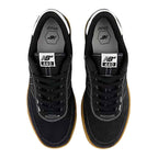 A pair of New Balance 440 sneakers shown from a top-down view. The shoes are primarily black suede and mesh with white contrast stitching, black laces, and a classic brown gum sole.