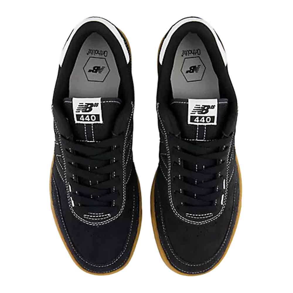 A pair of New Balance 440 sneakers shown from a top-down view. The shoes are primarily black suede and mesh with white contrast stitching, black laces, and a classic brown gum sole.