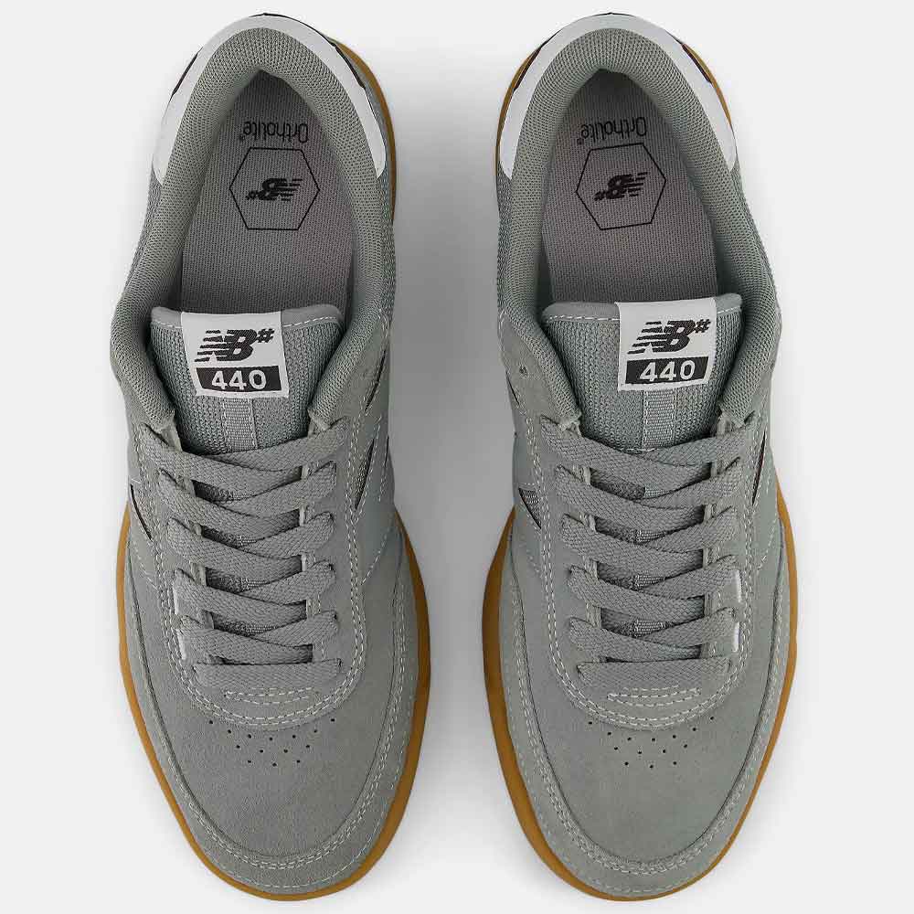 A pair of New Balance 440 sneakers shown from a top-down view. The shoes are primarily gray suede and mesh with white accents on the collar and tongue, and a brown gum sole.
