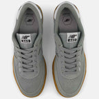 A pair of New Balance 440 sneakers shown from a top-down view. The shoes are primarily gray suede and mesh with white accents on the collar and tongue, and a brown gum sole.