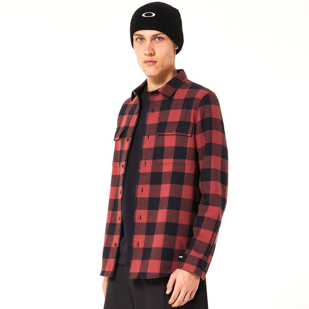Person wearing a red and black checkered shirt with a black beanie on a white background