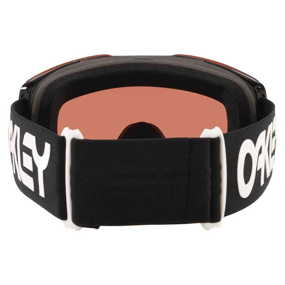 Oakley snow goggles with a black strap featuring white Oakley branding, a black foam nose pad, and a warm orange-tinted lens.