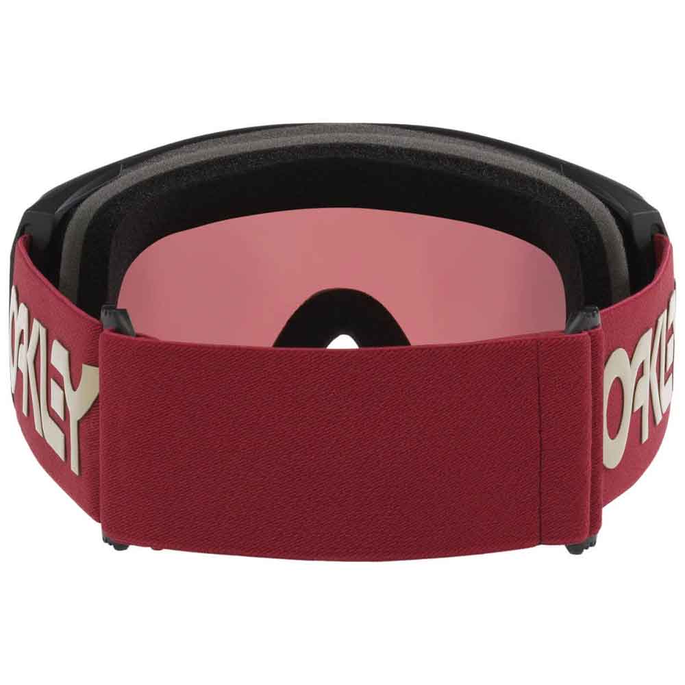 Oakley goggles with a burgundy elastic strap featuring a cream Oakley logo, a pink mirrored lens, and black foam padding.