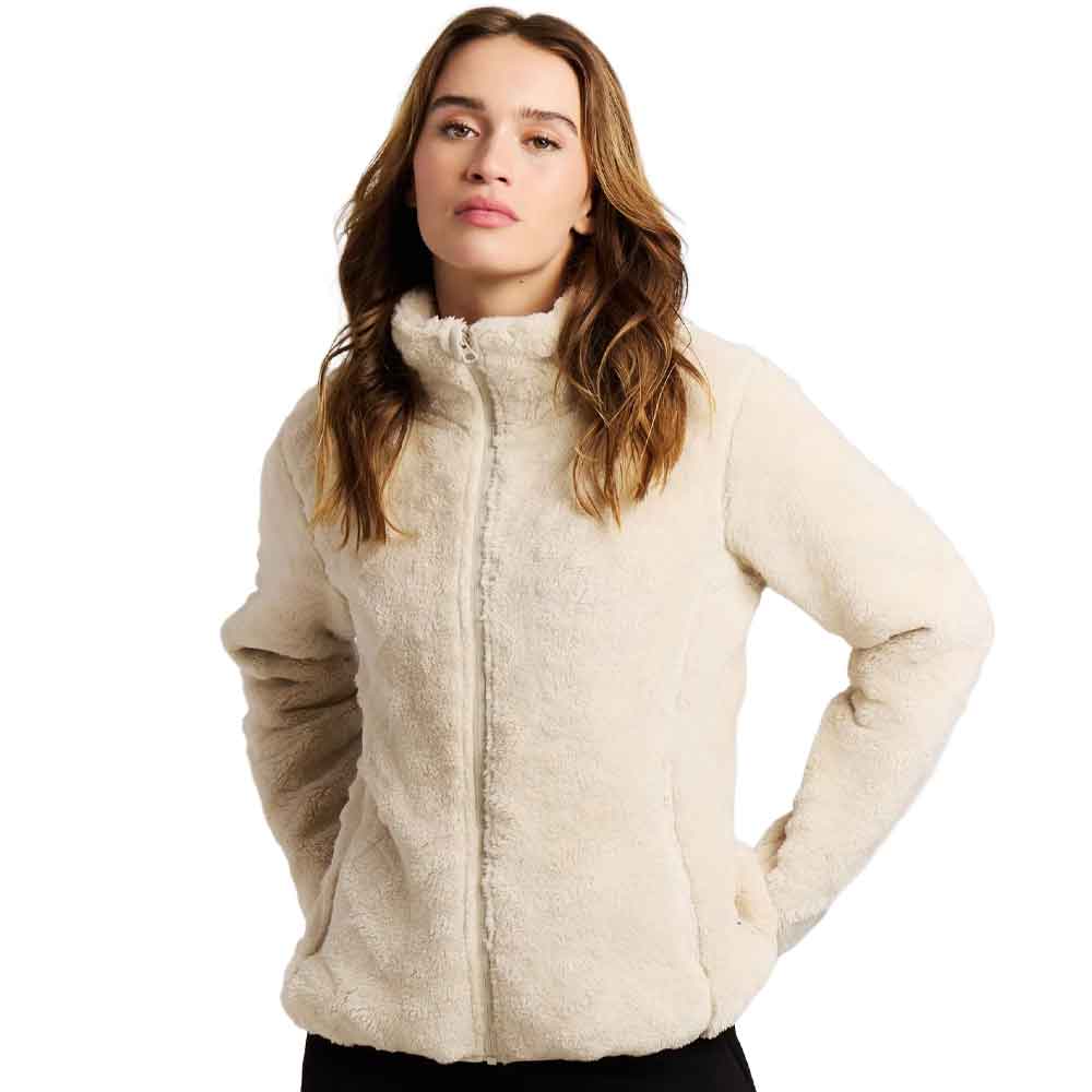 A woman modeling a cream-colored, sherpa fleece zip-up jacket against a plain white background.