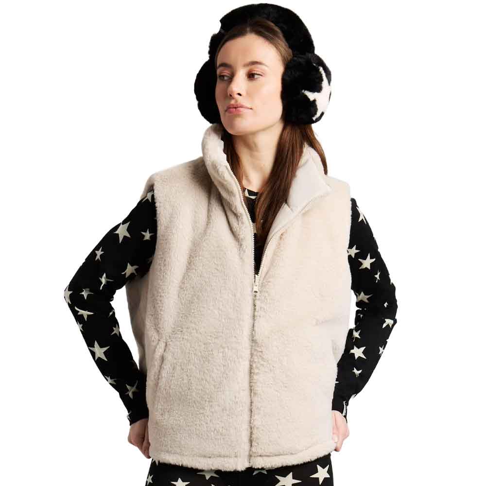 A woman wearing a cream sherpa fleece zip-up vest over a black long-sleeve shirt with white star print, paired with black and white earmuffs, against a plain white background.