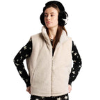 A woman wearing a cream sherpa fleece zip-up vest over a black long-sleeve shirt with white star print, paired with black and white earmuffs, against a plain white background.