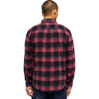 A man viewed from the back wearing a red and black buffalo plaid flannel shirt, paired with dark blue jeans, against a plain white background.