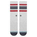 A pair of Stance crew socks in heather gray, featuring red and navy blue stripes near the cuff, a small circular logo, and the StANCE brand name printed in blue on the toes.