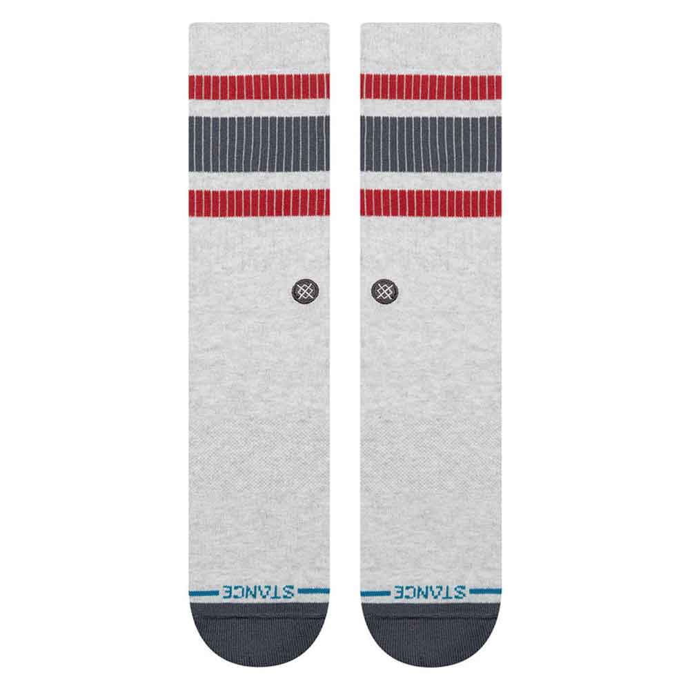 A pair of Stance crew socks in heather gray, featuring red and navy blue stripes near the cuff, a small circular logo, and the StANCE brand name printed in blue on the toes.
