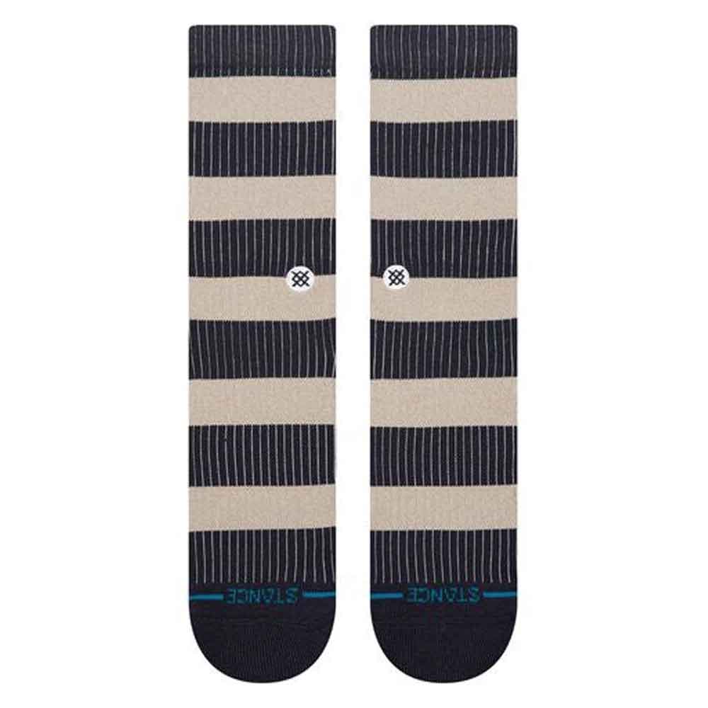A pair of Stance crew socks with horizontal stripes in navy blue and beige, featuring thin vertical pinstripes, a small checkered logo near the calf, and 'STANCE' printed in teal on the toes.