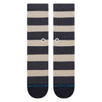 A pair of Stance crew socks with horizontal stripes in navy blue and beige, featuring thin vertical pinstripes, a small checkered logo near the calf, and 'STANCE' printed in teal on the toes.