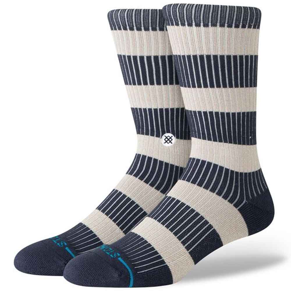 A pair of crew socks with navy blue and cream horizontal stripes, featuring thin vertical pinstripes, a small circular logo on the calf, and a light blue brand accent on the toes.