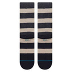 A pair of Stance crew socks with horizontal stripes in navy blue, beige, and thin white pinstripes, featuring a light blue Stance logo on the side.