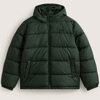 A dark forest green hooded puffer jacket with horizontal quilting, a front zipper, and side pockets, shown against a light off-white background.