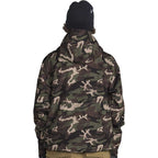 A person shown from the back wearing a camouflage hooded jacket, a black beanie, and tan pants against a plain white background.
