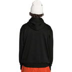 A person shown from the back wearing a black pullover hoodie, a white beanie, and bright orange pants 