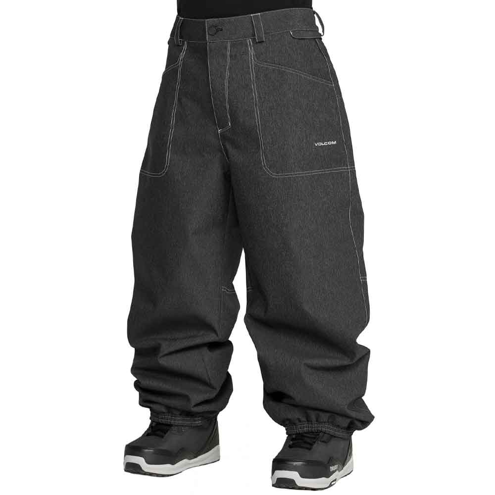 Dark gray Volcom snow pants with contrast white stitching, shown on a model from the waist down wearing black and white sneakers against a white background.