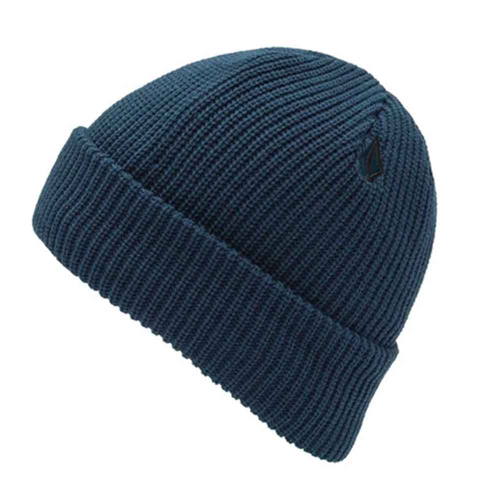 A dark navy blue ribbed knit beanie hat with a small black embroidered Volcom logo on the side, shown against a plain white background.