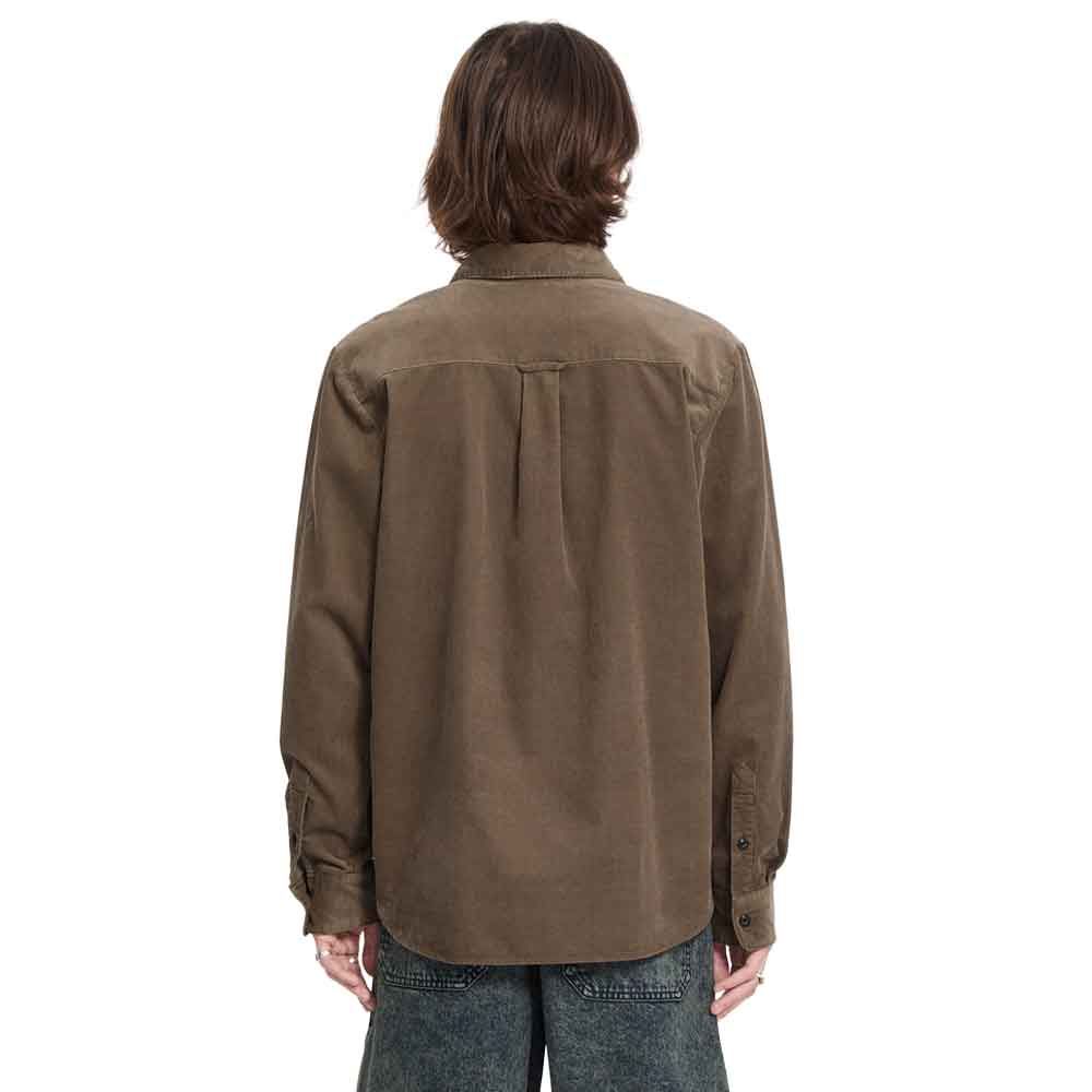 A person viewed from the back wearing a brown corduroy button-up shirt and blue jeans against a plain white background.